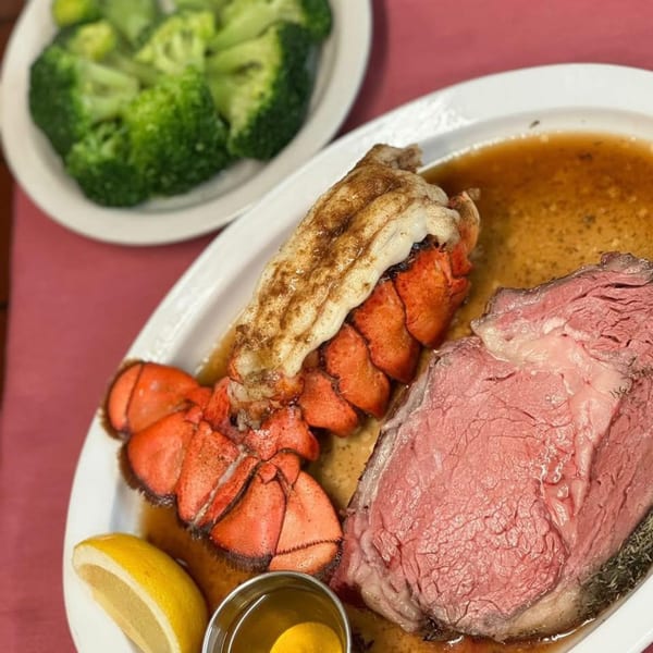 Coach & Four's prime rib and lobster tail with lemon and a side of broccoli.